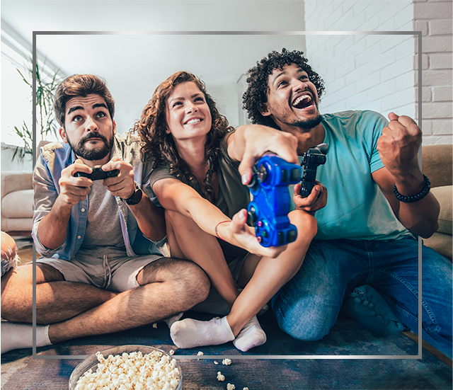 Skupina mladých usmievajúcich sa ľudí sedí na podlahe a hrá videohry