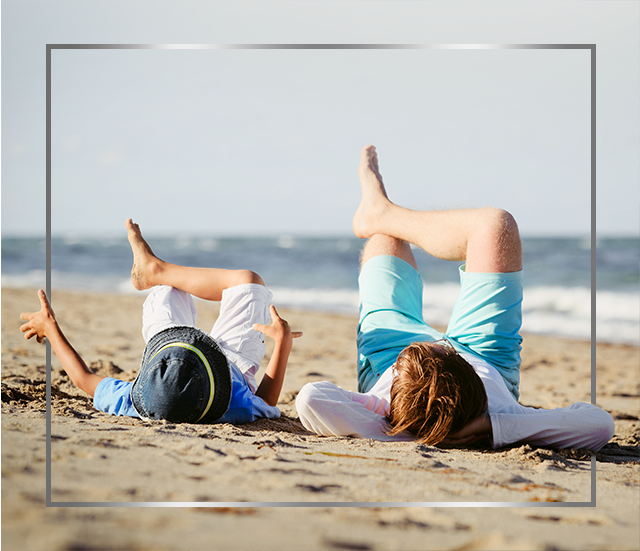 Matka a dieťa ležia na pláži s prekríženými nohami, sú šťastní po liečbe plesňovej infekcie kože prípravkom Canesten krém